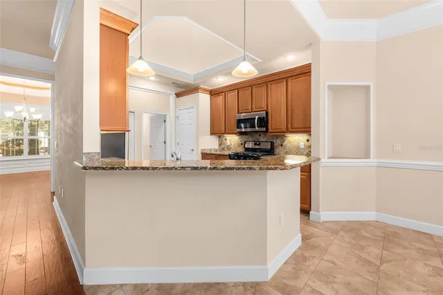 a kitchen with kitchen island a counter top space a sink stainless steel appliances and cabinets