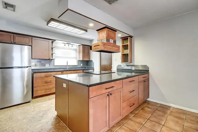 a kitchen with granite countertop a sink stainless steel appliances and cabinets