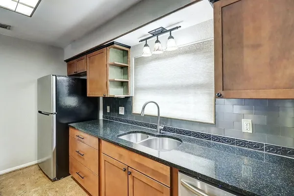 a kitchen with stainless steel appliances granite countertop a sink refrigerator and microwave