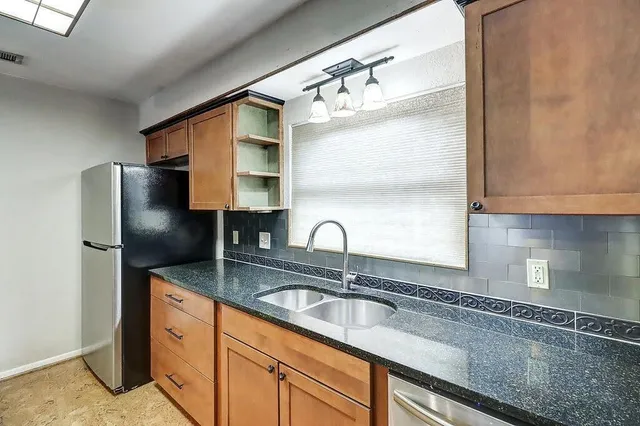 a kitchen with stainless steel appliances granite countertop a sink refrigerator and microwave