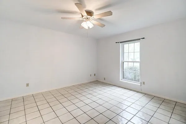 an empty room with windows and ceiling fan
