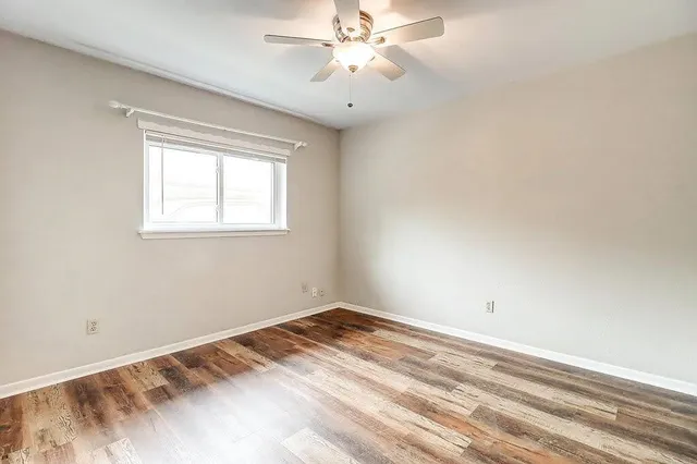a view of a room with a ceiling fan and a window