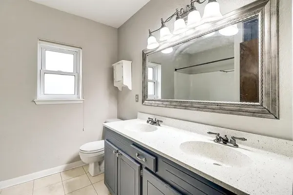 a bathroom with a toilet sink and mirror