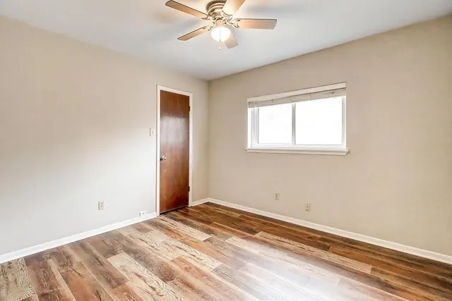 a view of a bedroom with wooden floor and windows