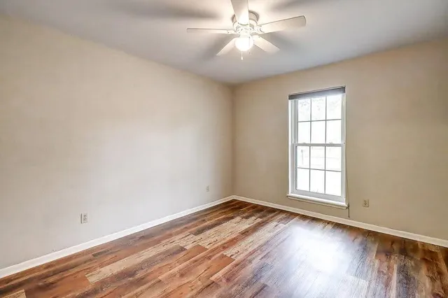 wooden floor in an empty room with a window