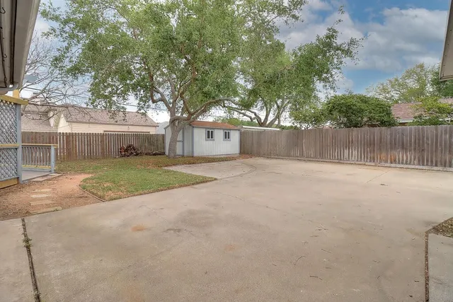 a view of backyard with a garden and trees