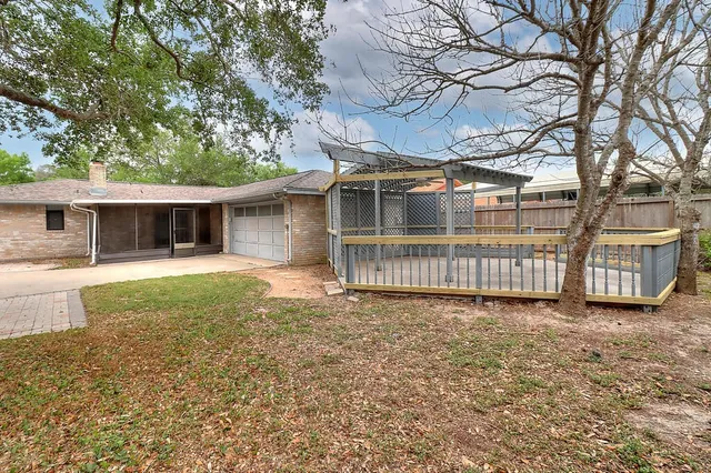 a view of a house with a yard and fence