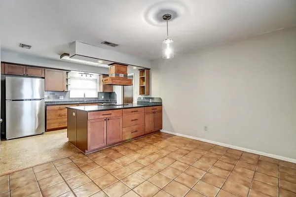 a kitchen with stainless steel appliances granite countertop a refrigerator a sink and a stove