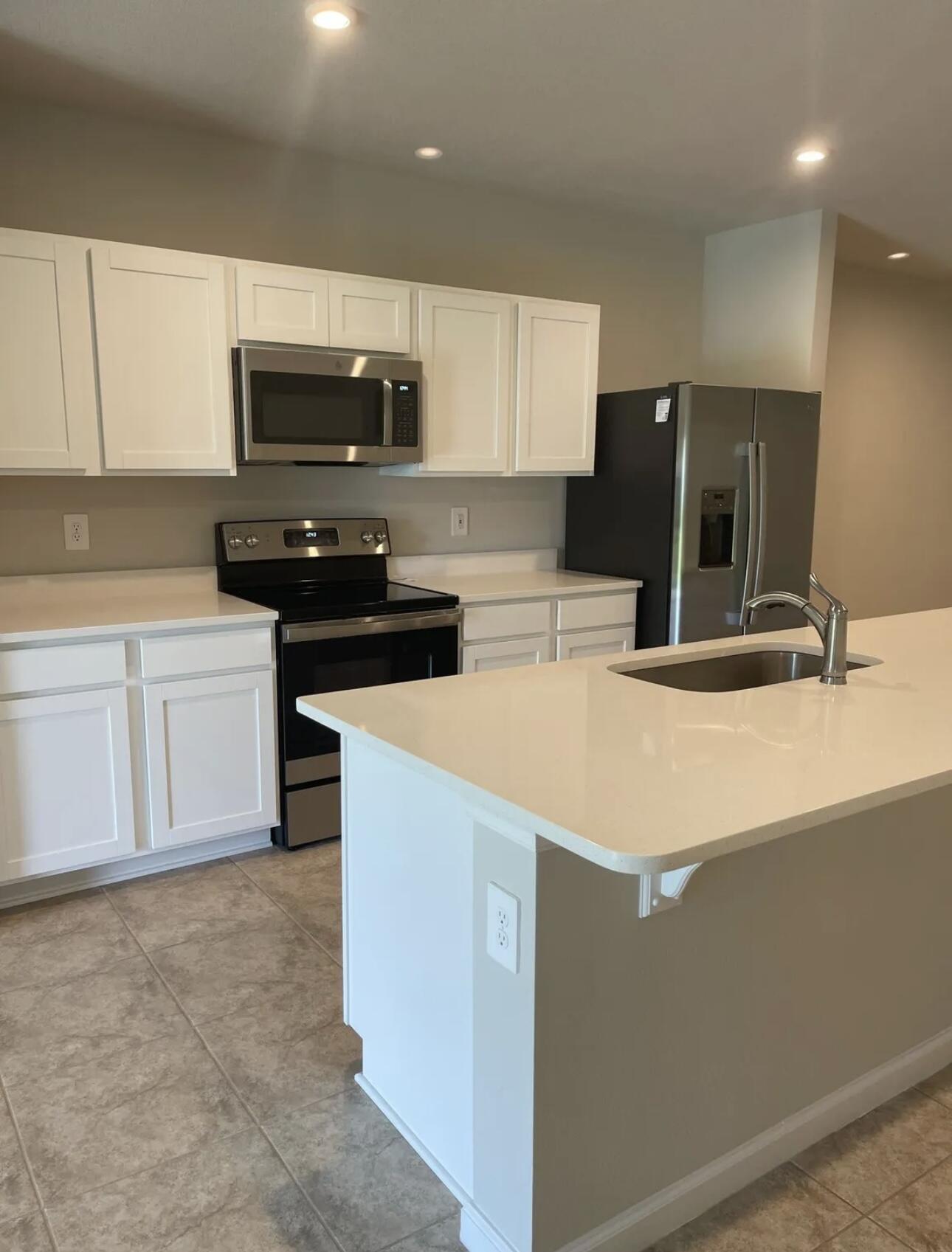 227 Raspberry Road Fort Pierce, FL 34981 - Photo 2 of 12 a kitchen with stainless steel appliances a stove microwave and sink