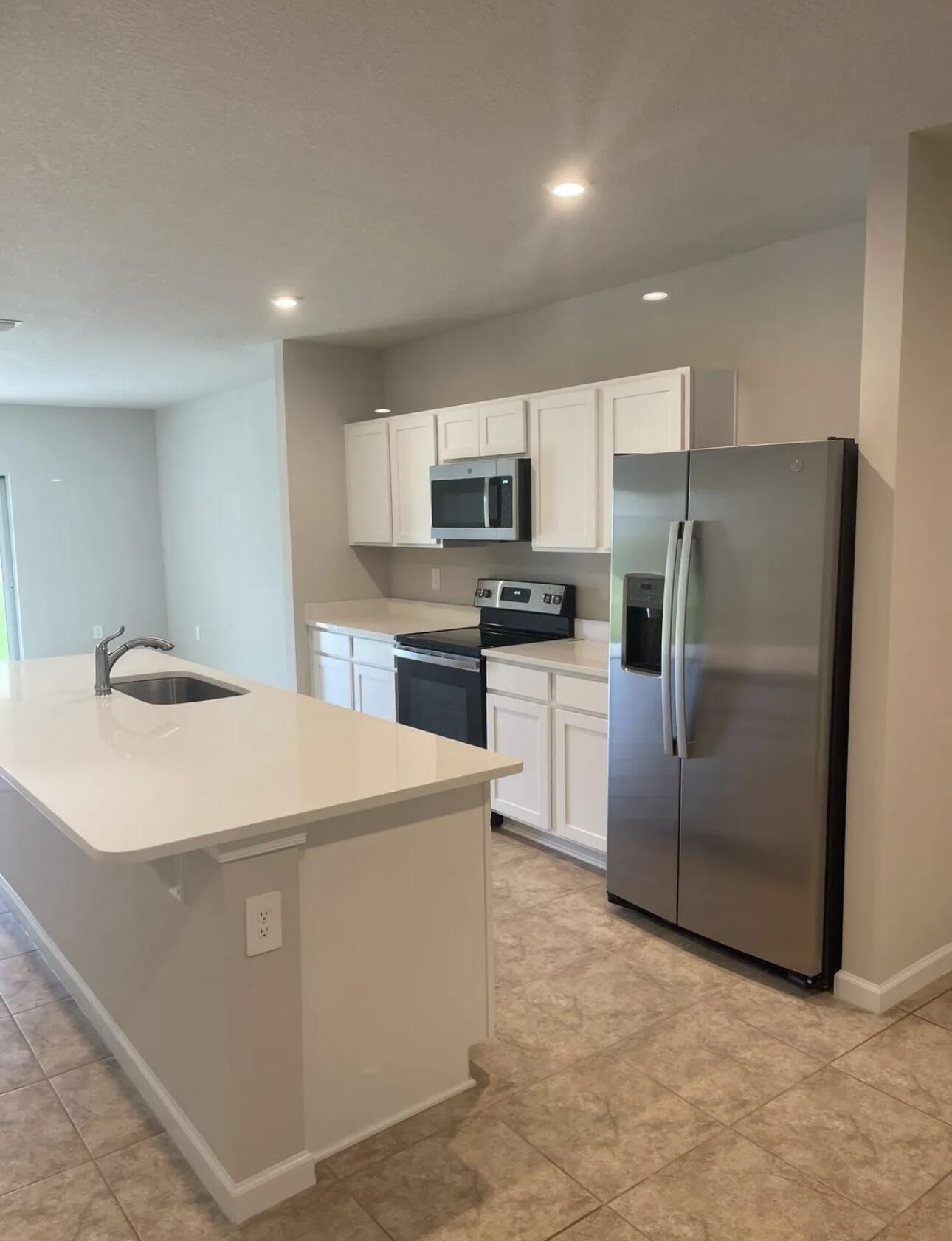 227 Raspberry Road Fort Pierce, FL 34981 - Photo 9 of 12 a kitchen with stainless steel appliances a refrigerator sink and microwave