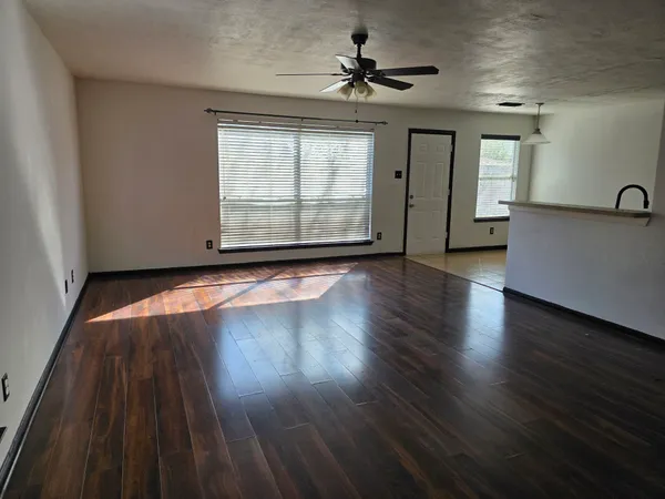 a view of a livingroom with wooden floor and a ceiling fan