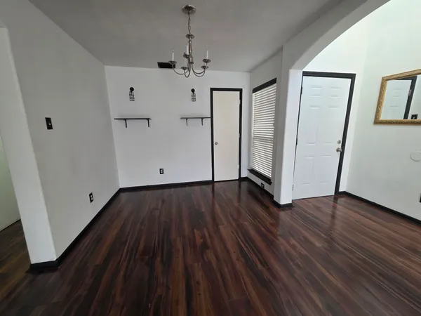 a view of empty room with wooden floor and window
