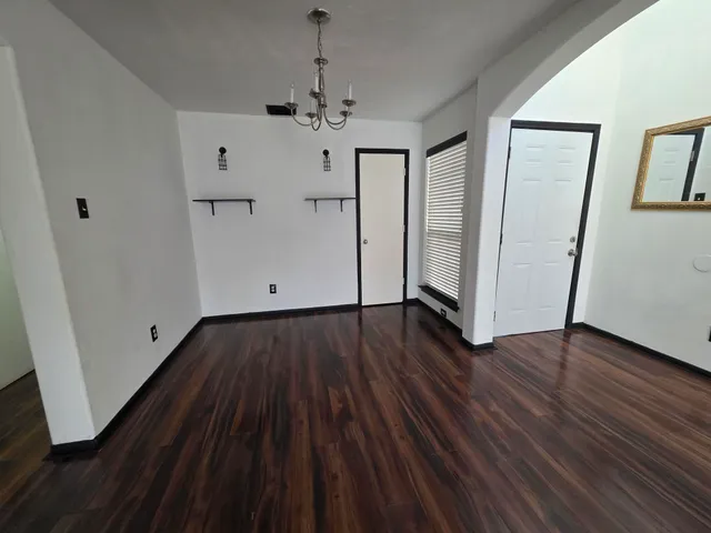 a view of empty room with wooden floor and window