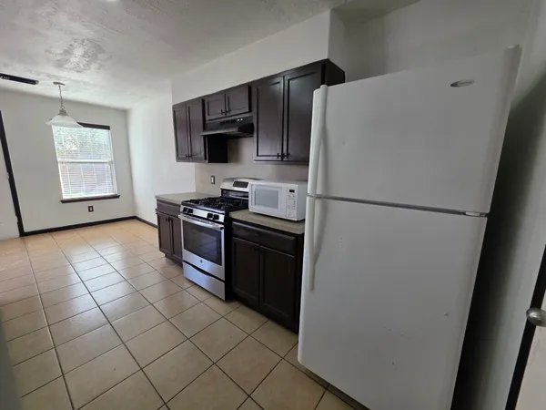 a kitchen with a refrigerator a stove a microwave and sink