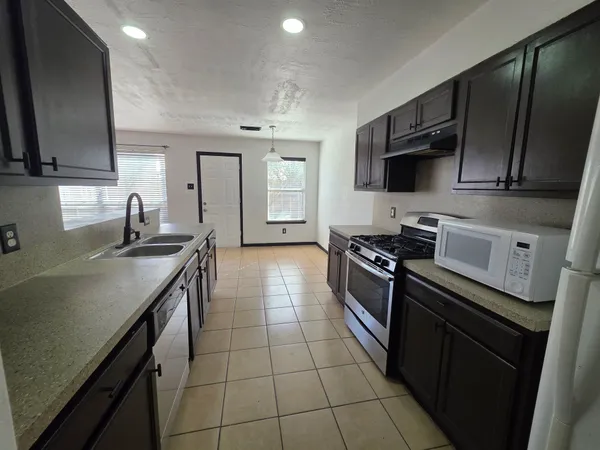 a kitchen with a sink stove and microwave