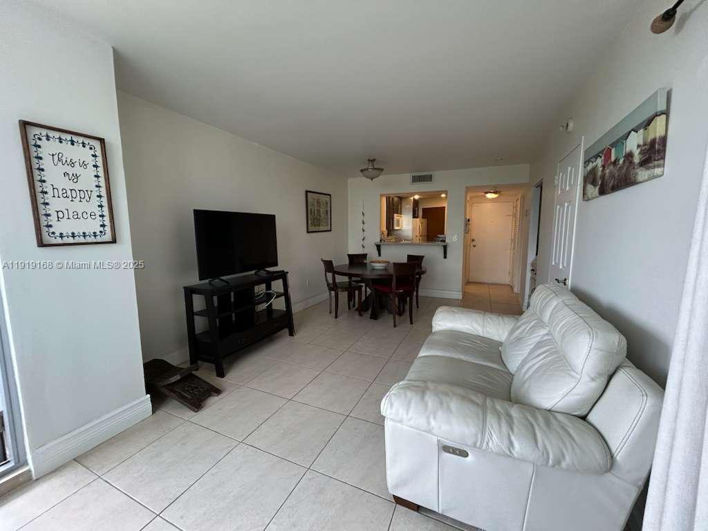 2899 Collins Avenue, Unit 625 Miami Beach, FL 33140 - Photo 2 of 7 a living room with furniture and a flat screen tv