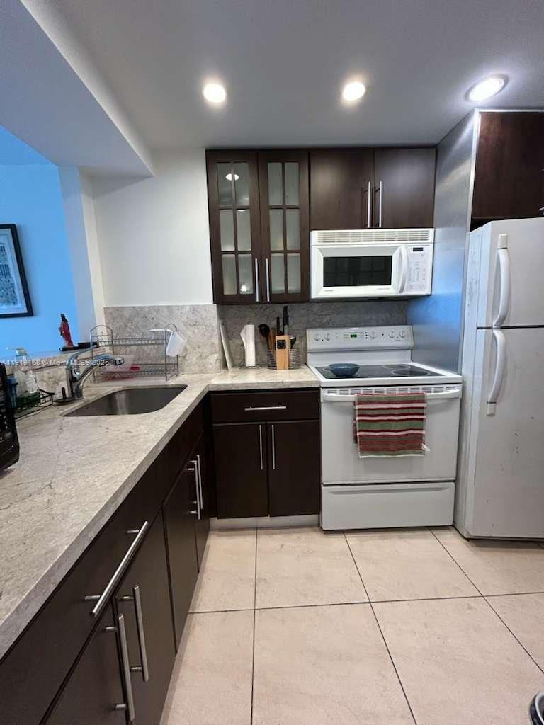 2899 Collins Avenue, Unit 625 Miami Beach, FL 33140 - Photo 5 of 7 a kitchen with a sink stove and refrigerator