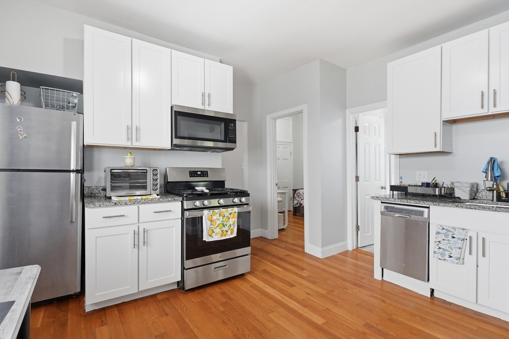 1661 North Shore Road Revere, MA 02151 - Photo 26 of 42 a kitchen with stainless steel appliances granite countertop a refrigerator stove a sink and a microwave