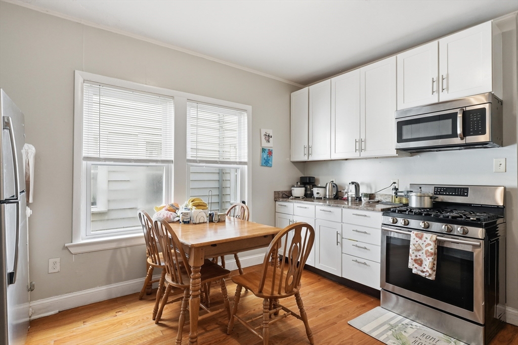 1661 North Shore Road Revere, MA 02151 - Photo 4 of 42 a kitchen with stainless steel appliances granite countertop a stove a sink a microwave and a refrigerator