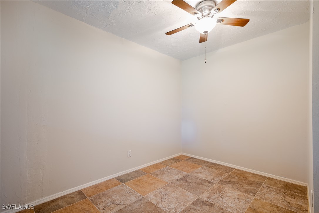 8025 Anhinga Road Fort Myers, FL 33967 - Photo 12 of 47 an empty room with a window and a ceiling fan