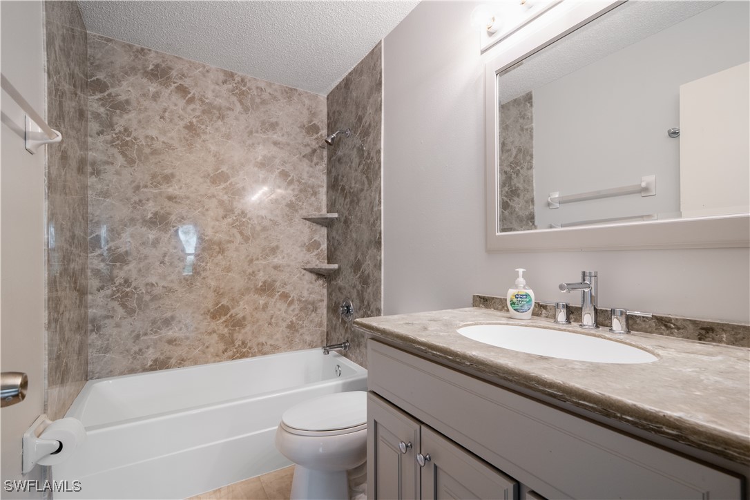 8025 Anhinga Road Fort Myers, FL 33967 - Photo 29 of 47 a bathroom with a granite countertop sink a toilet and bathtub