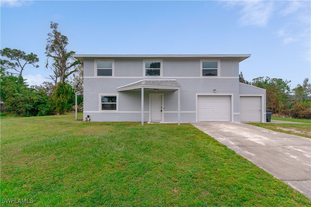 8025 Anhinga Road Fort Myers, FL 33967 - Photo 36 of 47 a front view of a house with a garden and yard