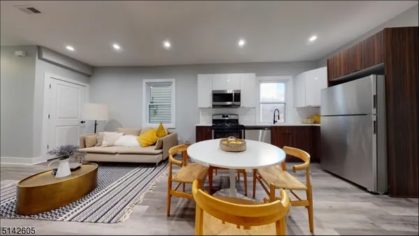 a living room with furniture and a dining table with wooden floor