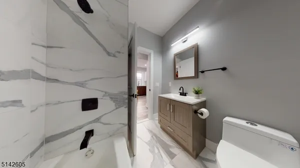 a bathroom with a sink and mirror with toilet