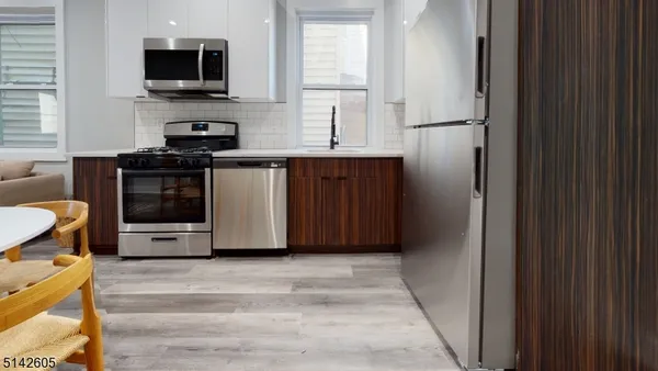 a kitchen with stainless steel appliances a stove a microwave and a refrigerator