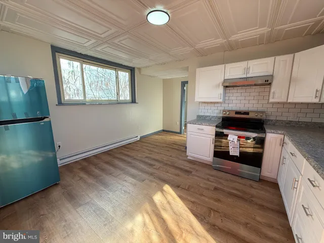 a kitchen with granite countertop a refrigerator and a stove
