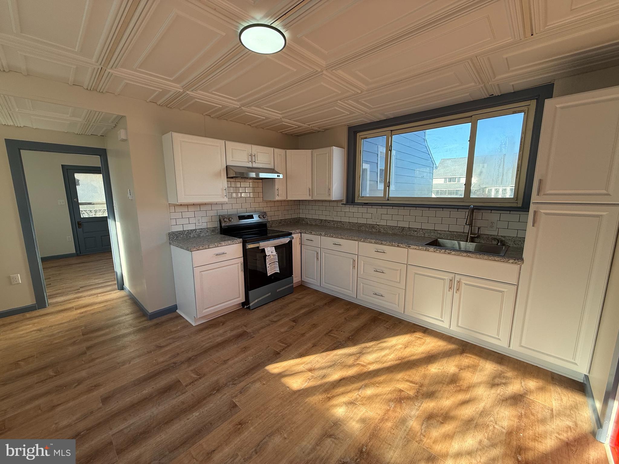 5036-3 Leesport Avenue Temple, PA 19560 - Photo 3 of 9 a kitchen with granite countertop a stove a sink and a microwave