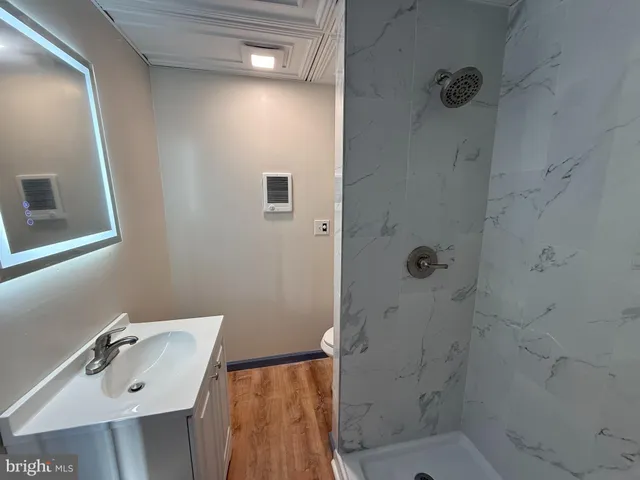 a bathroom with a sink a toilet and shower