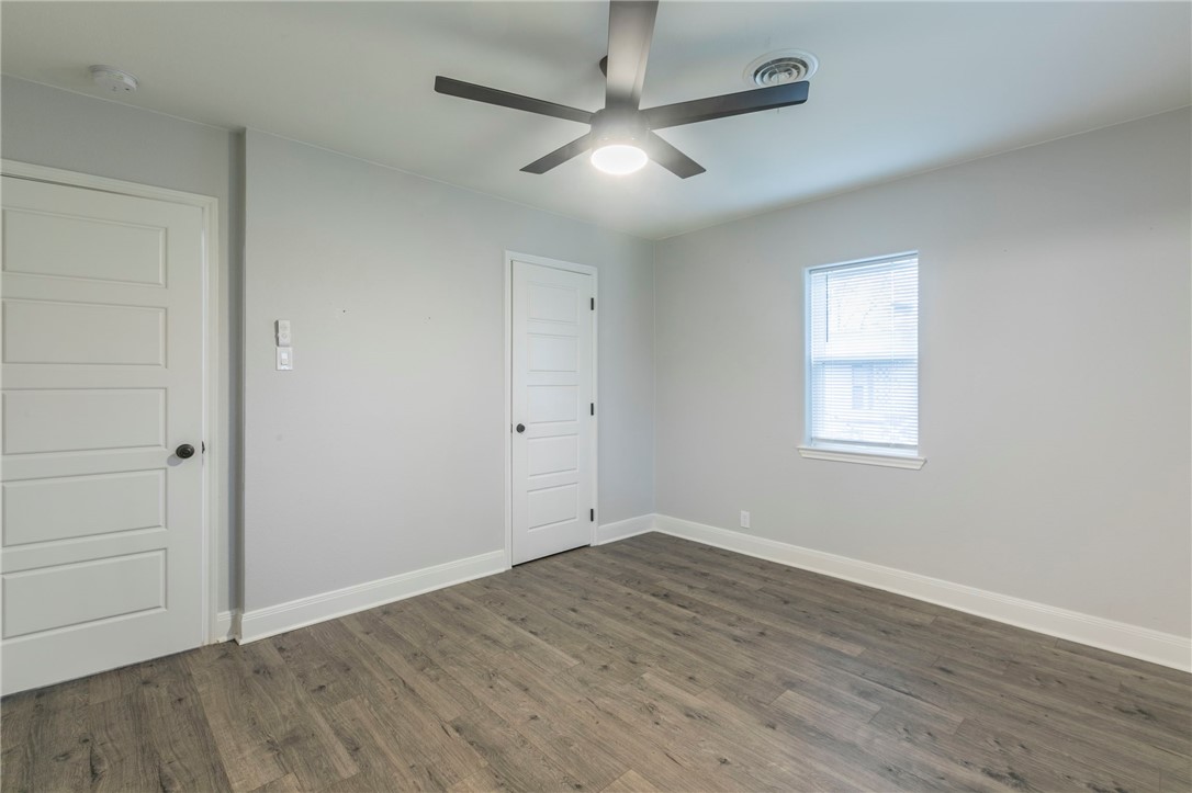 105 Alamo Drive McGregor, TX 76657 - Photo 17 of 34 an empty room with wooden floor ceiling fan and windows