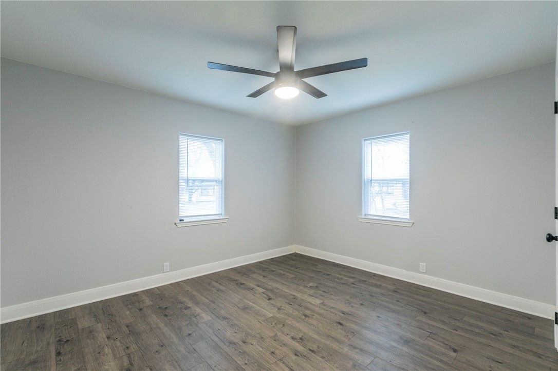 105 Alamo Drive McGregor, TX 76657 - Photo 21 of 34 an empty room with wooden floor ceiling fan and windows