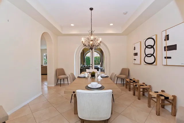 a living room with furniture a chandelier and a large window