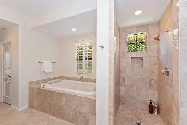 a bathroom with a granite countertop bathtub shower sink and mirror