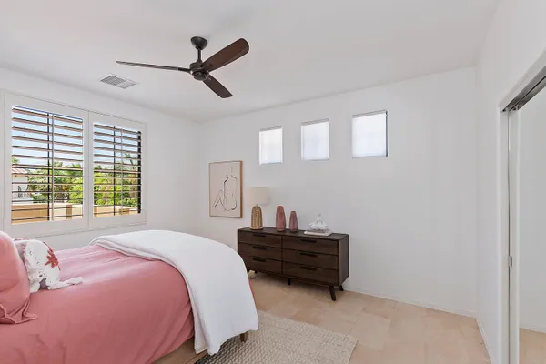 a bedroom with a bed and a ceiling fan