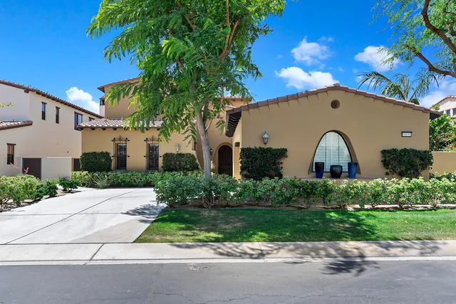 a front view of a house with a garden and plants