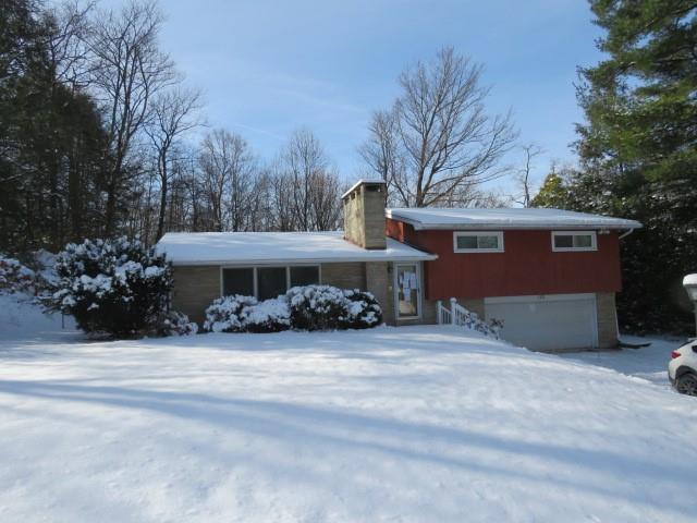 a view of a house with a yard and a garage