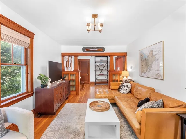 a living room with furniture a fireplace and large windows