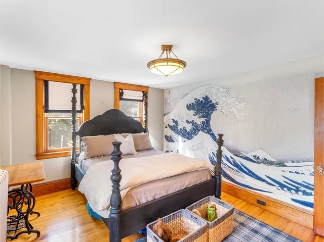 a bedroom with a bed and wooden floor