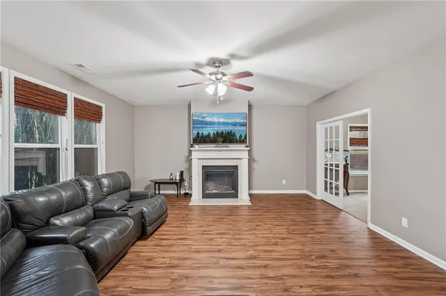 a kitchen with stainless steel appliances granite countertop wooden cabinets a sink dishwasher and a stove top oven with wooden floor