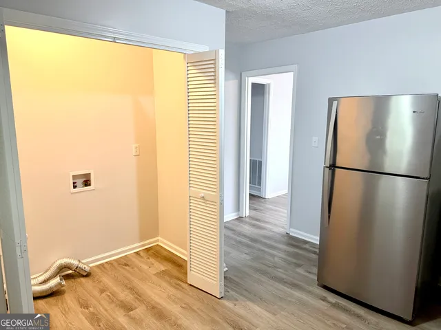 a view of a refrigerator in kitchen and wooden floor