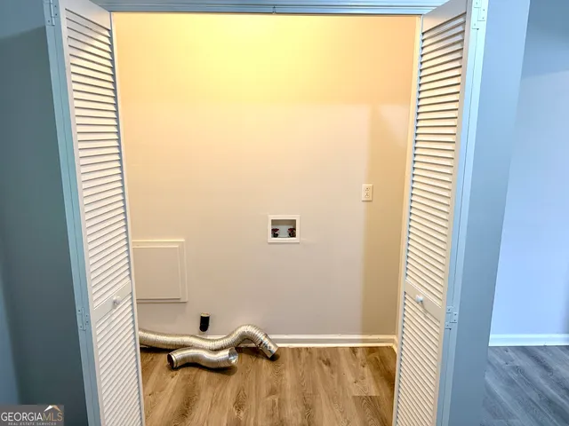a view of a room with a window and a white wooden floor