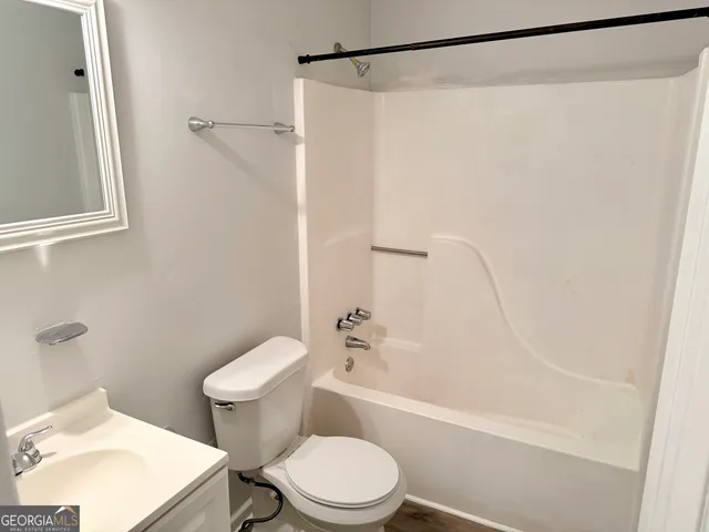 a white toilet sitting next to a bath tub