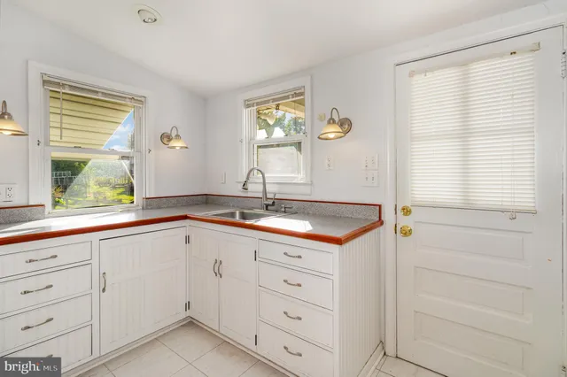 a kitchen with white cabinets and a window