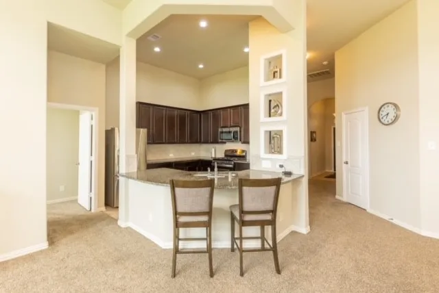 a kitchen with stainless steel appliances granite countertop a refrigerator and a sink