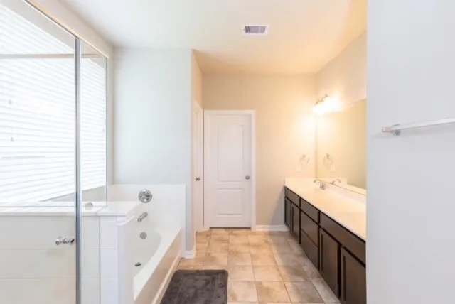 a bathroom with a bathtub a shower and a window