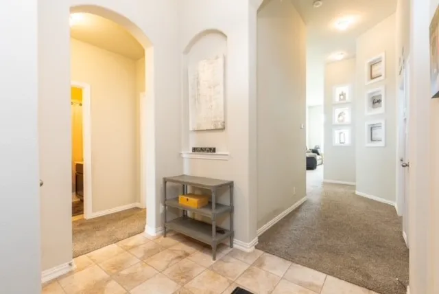 a view of a hallway with wooden floor and a bathroom