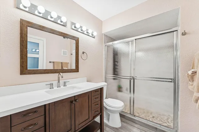 a bathroom with a double vanity sink mirror and toilet
